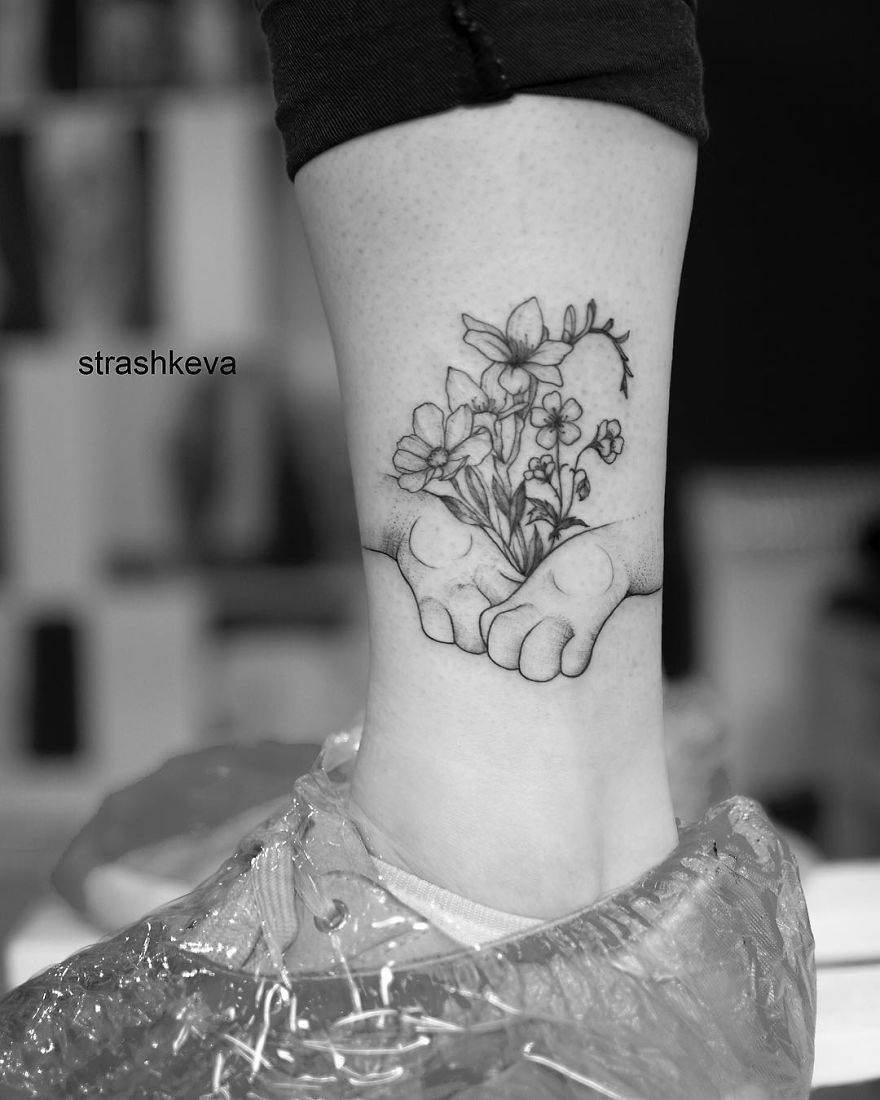 Floral tattoo on a wrist by Lublin-based artist, showing delicate flowers and hands in black ink.