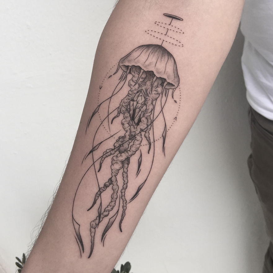 Geometric tattoo of a jellyfish on forearm, showcasing intricate linework and shading.