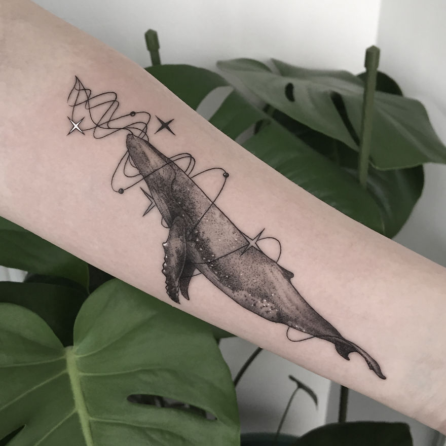 Geometric tattoo of a whale with abstract lines on forearm, symbolizing personal life events.