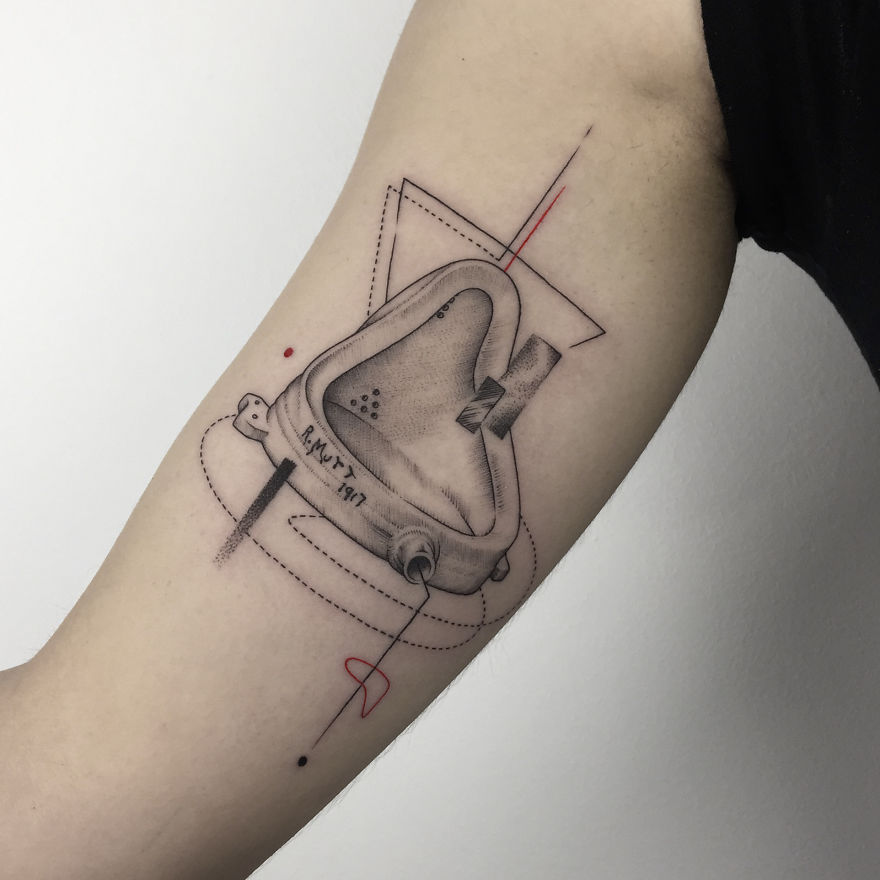 Geometric tattoo design on arm, featuring abstract shapes with fine lines and shading.