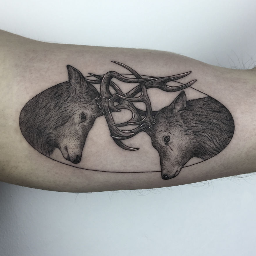 Geometric tattoo design of two animal heads with intertwining antlers, symbolizing life events.