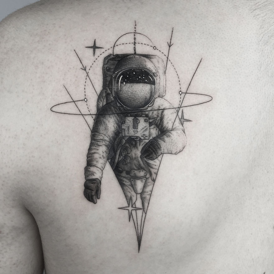 Geometric tattoo of an astronaut with triangular and circular elements on a person's back.