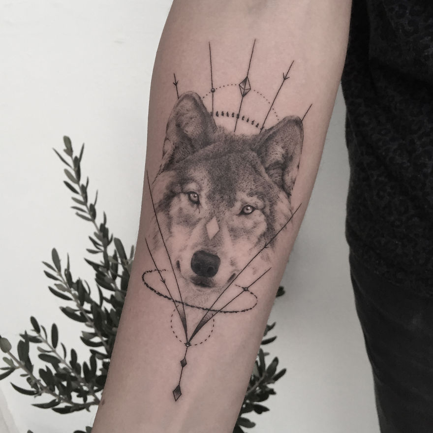 Geometric tattoo design featuring a wolf on forearm, symbolizing life events.