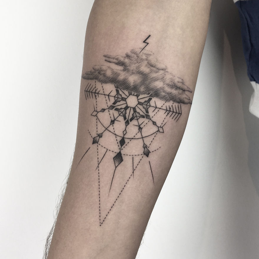 Geometric tattoo design on forearm, featuring cloud with lightning and intricate symmetrical patterns.