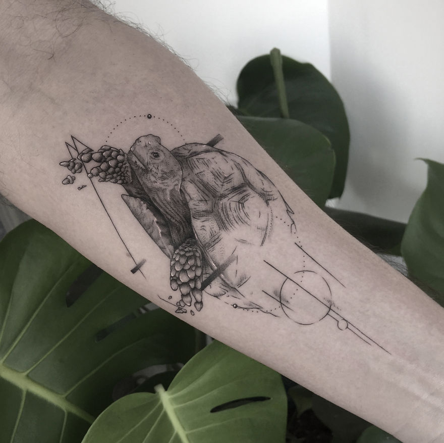 Geometric tattoo design of a turtle on forearm, blending nature with modern lines and shapes.