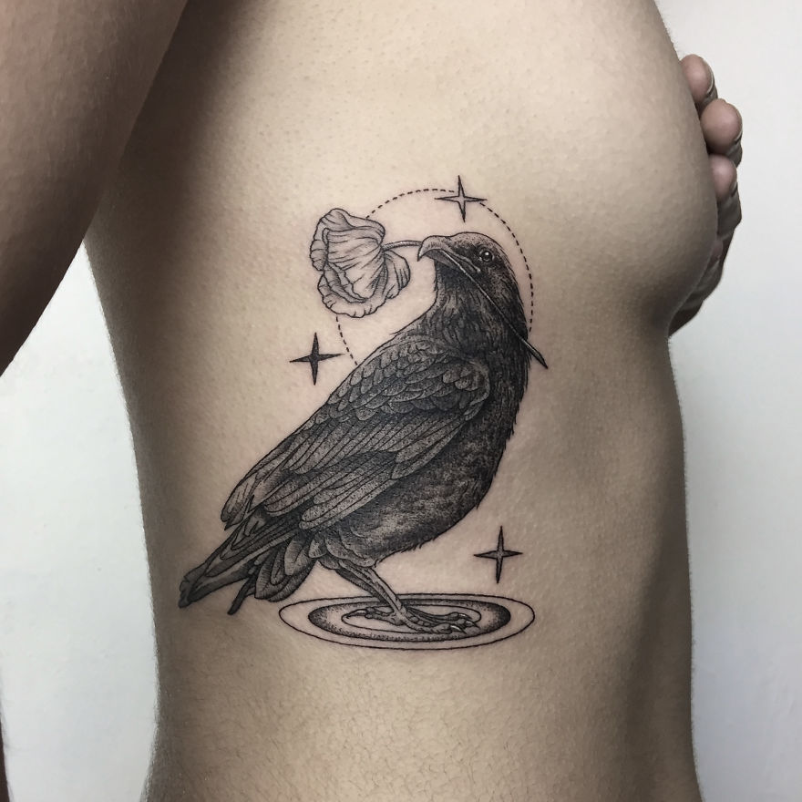 Geometric tattoo of a raven on a person's side, incorporating stars and a leaf detail.
