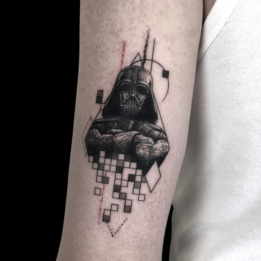 Geometric tattoo design featuring iconic sci-fi helmet with abstract shapes and lines on arm.