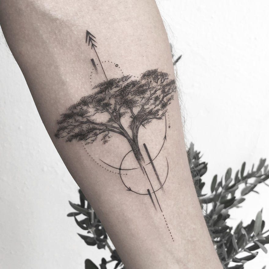 Geometric tattoo design featuring a tree with abstract circles and lines on a person's arm.