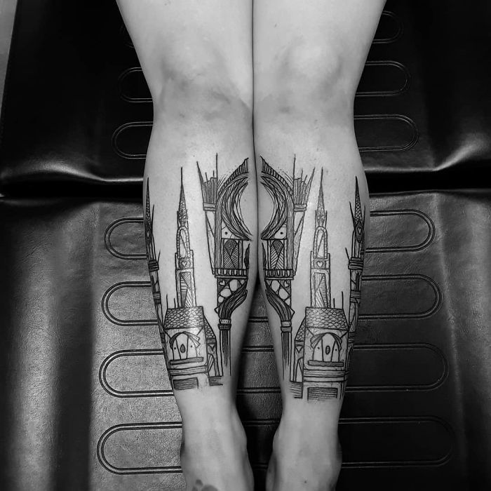 Detailed leg sleeve tattoo with architectural design elements on a person's calves.