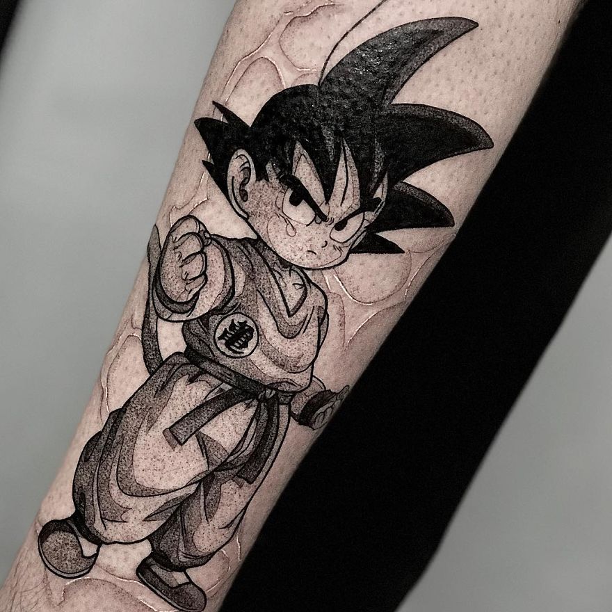 Dragon Ball tattoo of a character Baby Goku with spiky hair and martial arts attire on forearm.