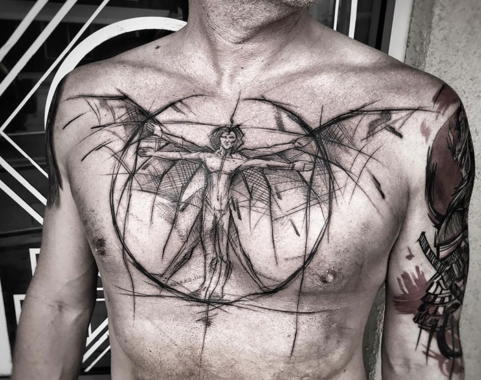 Incredible chest tattoo featuring a sketch of Da Vinci's Vitruvian Man design.