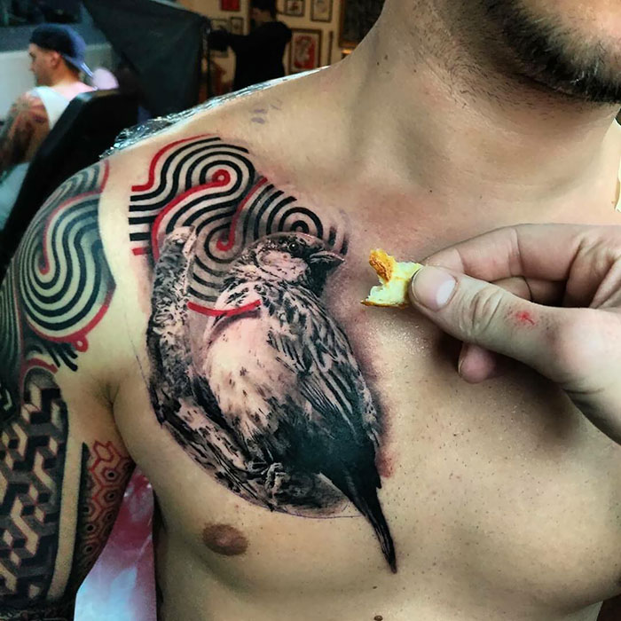 Chest tattoo featuring a detailed bird design with abstract patterns.