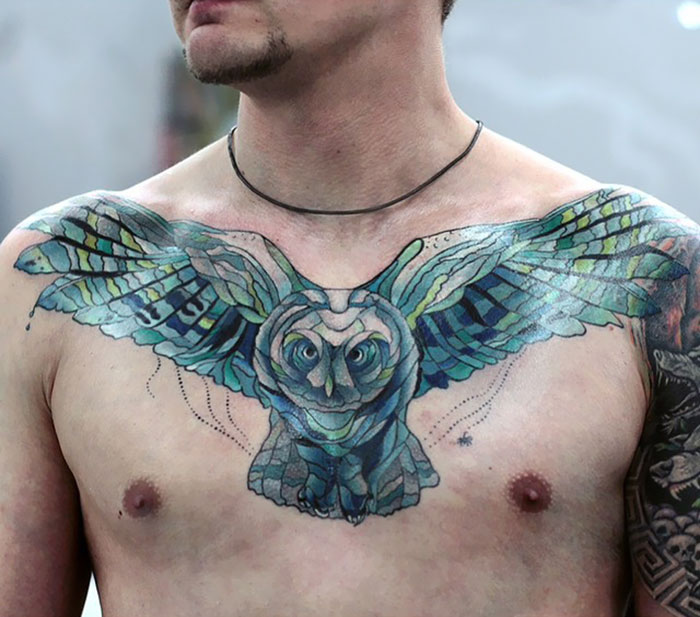 Man with an intricate owl chest tattoo, showcasing a vibrant and incredible ink design.