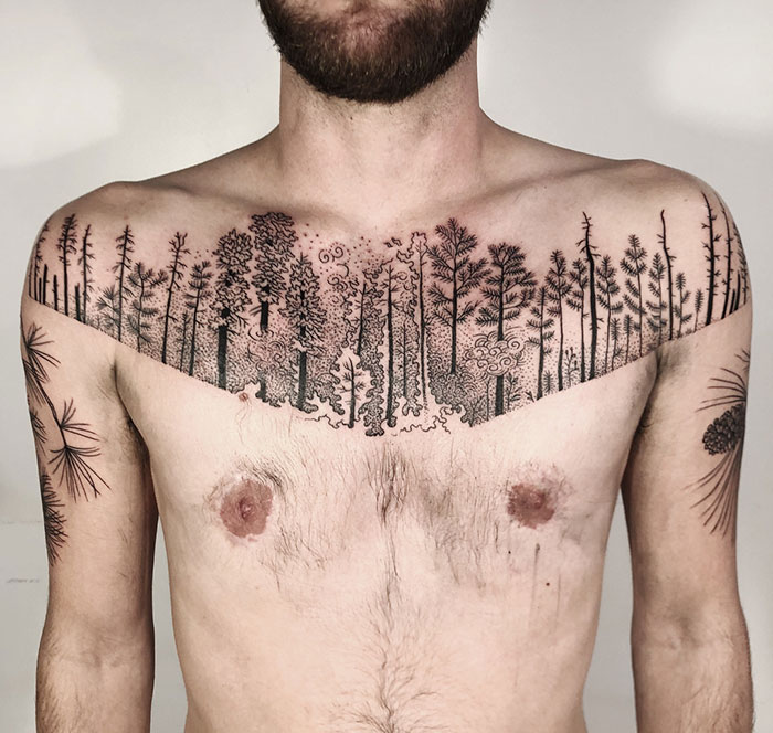 Man with incredible chest tattoo featuring an intricate forest design.