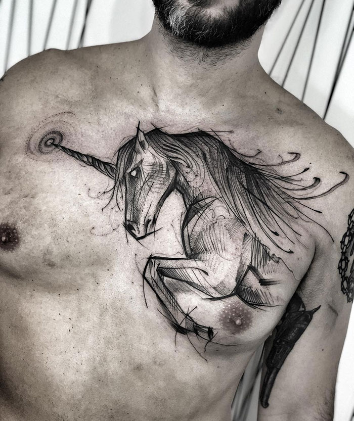 Chest tattoo of a detailed abstract unicorn design on a man's chest.