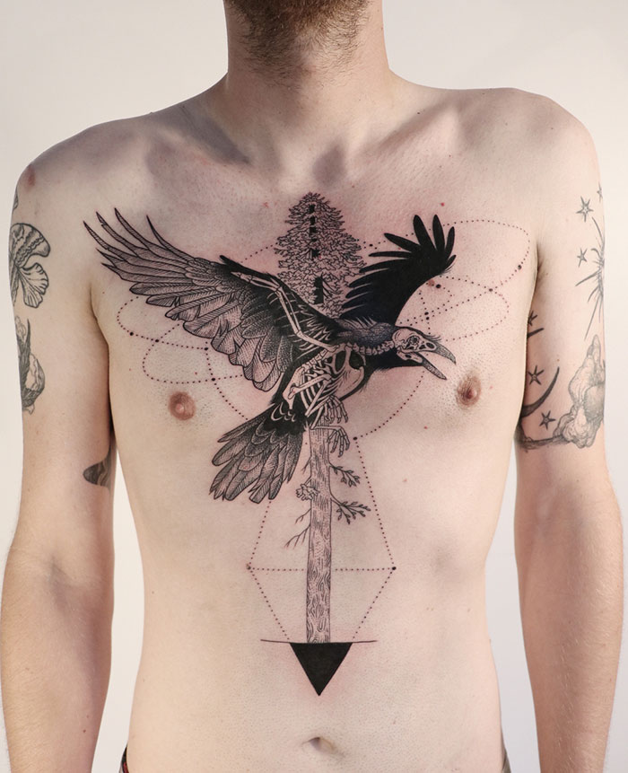 Chest tattoo with intricate raven design featuring geometric elements.