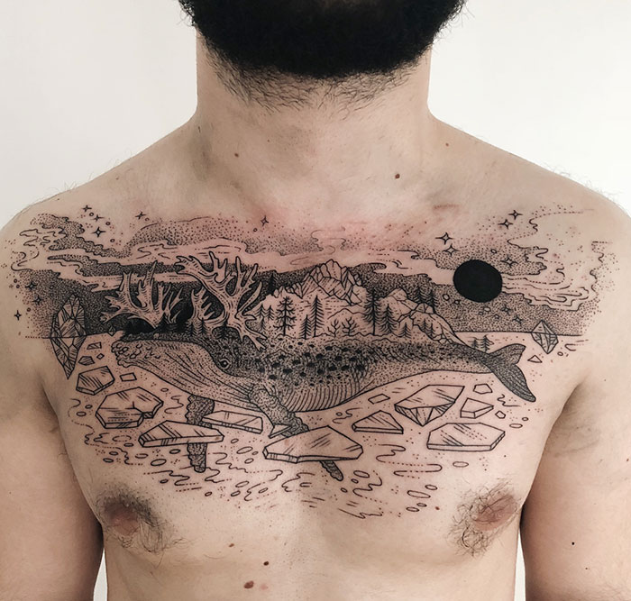 Incredible chest tattoo featuring a whale, mountains, and geometric shapes in a detailed, artistic style.