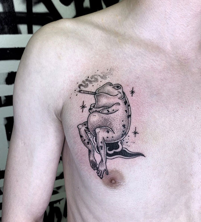 Frog chest tattoo with stars, featuring unique ink design.
