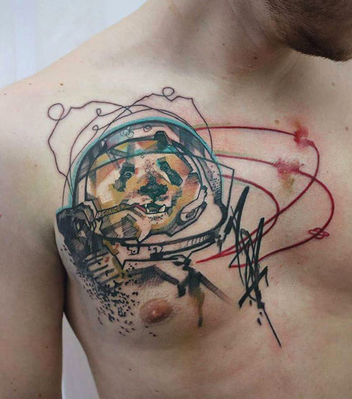 Abstract dog astronaut chest tattoo design, combining vibrant colors and bold lines, showcasing incredible tattoo art ideas.