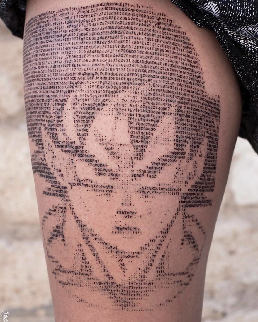 ASCII-style Dragon Ball tattoo on thigh, depicting a character Goku with detailed text and symbols for artistic effect.