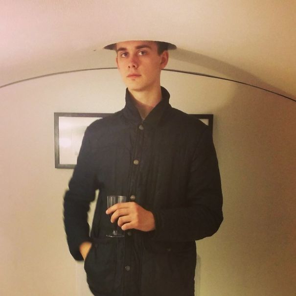 Tall person standing under a low ceiling opening, illustrating everyday struggles of tall people in a humorous way.