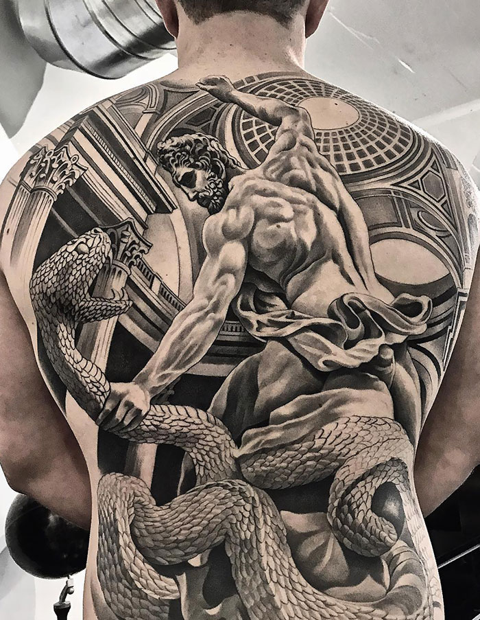 Detailed back tattoo depicting a muscular figure wrestling a serpent, showcasing impressive artistry and skill.