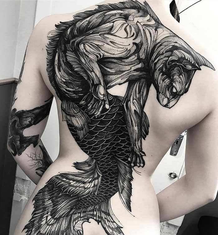 A stunning back tattoo featuring a detailed black and white design, showcasing a creative masterpiece.