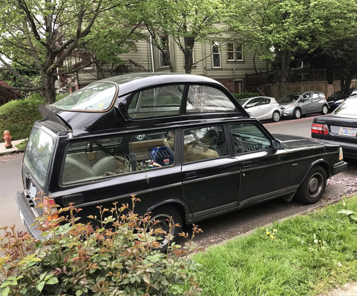 Funny car with a tiny car on its roof spotted on a street.
