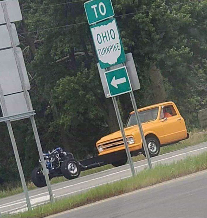 Funny car spotted with missing front half near Ohio Turnpike sign.