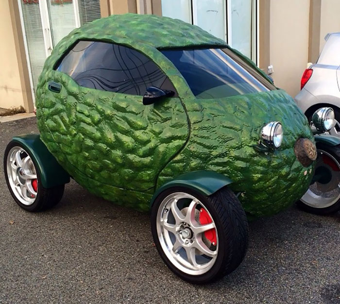 Funny car shaped like an avocado parked on the street.