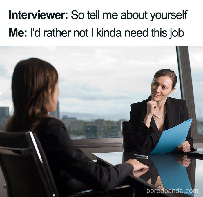 Two women in an office setting during a humorous job interview moment, one holding a blue folder.
