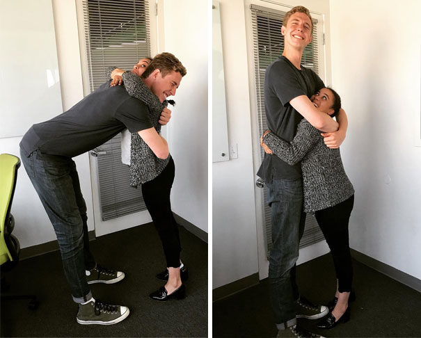Tall man hugging shorter woman indoors, illustrating the everyday struggles of tall people with height differences.