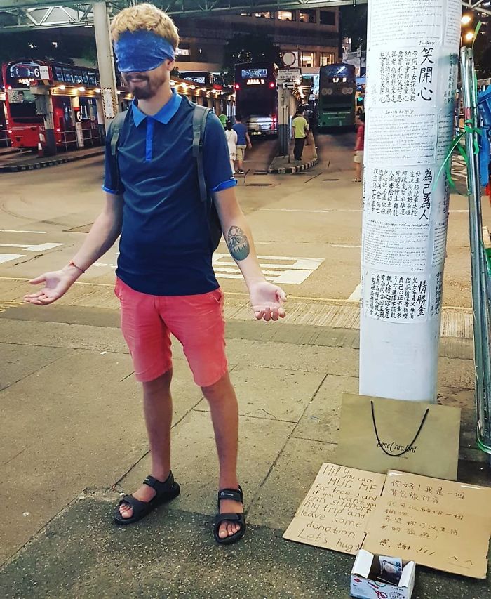 His Signs Reads: "You Can Hug Me For Free And If You Want You Can Support My Trip And Leave Some Donation Let's Hug" 