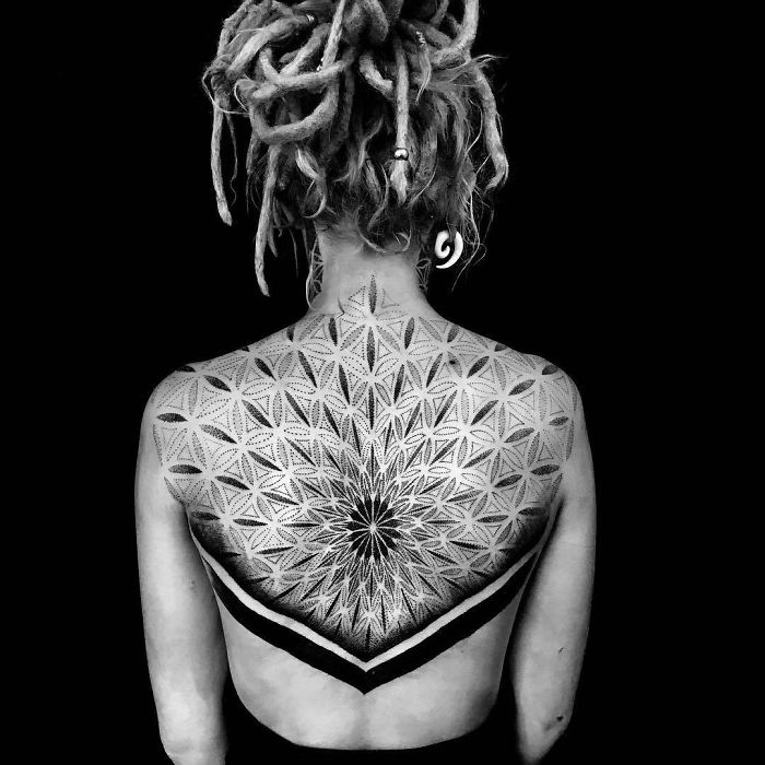 Intricate geometric back tattoo with detailed patterns, showcasing an impressive masterpiece design.