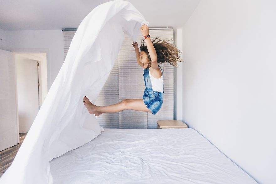 Little Girl Jumping On The Bed And Having Fun