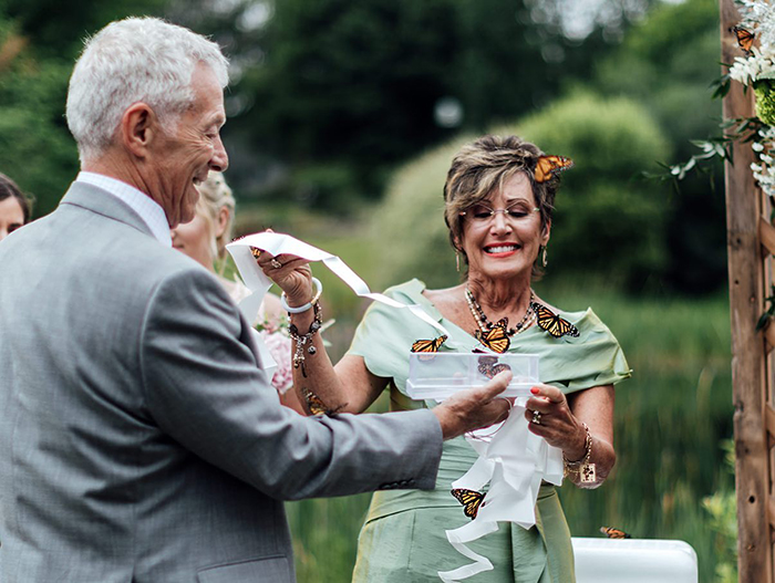 Family releases butterflies during wedding to honor sister who died, with one butterfly landing on father's hand. Family releases butterflies during wedding to honor sister who died, with one butterfly landing on father's hand.