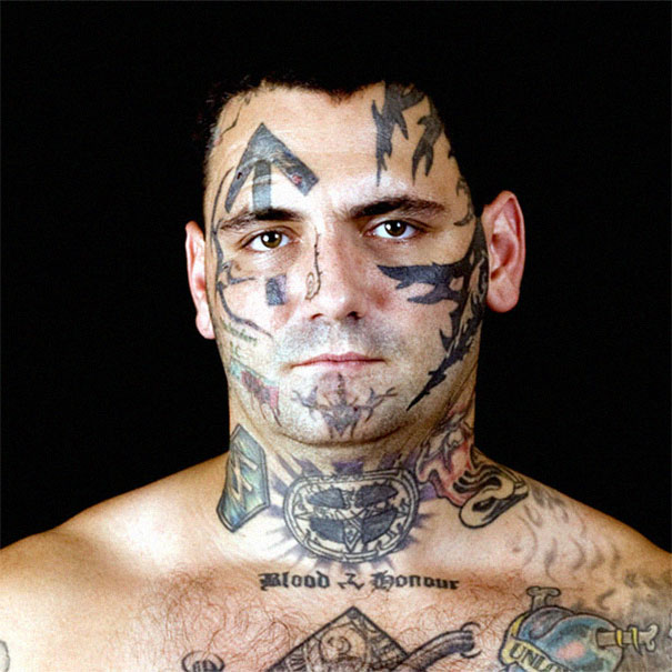 Ex-skinhead with tattoos on face and chest, looking directly ahead. Ex-skinhead with tattoos on face and chest, looking directly ahead.