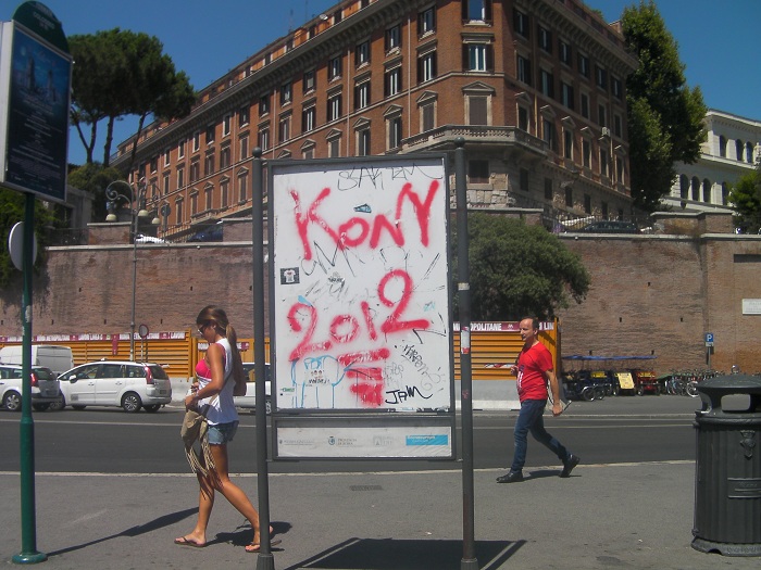 Street scene with a graffiti-covered signboard and pedestrians, reflecting hottest trends from the past decade.