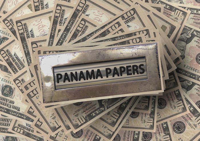 Stack of US dollar bills with a metal label holder reading Panama Papers, highlighting forgotten hottest trends of the past decade.