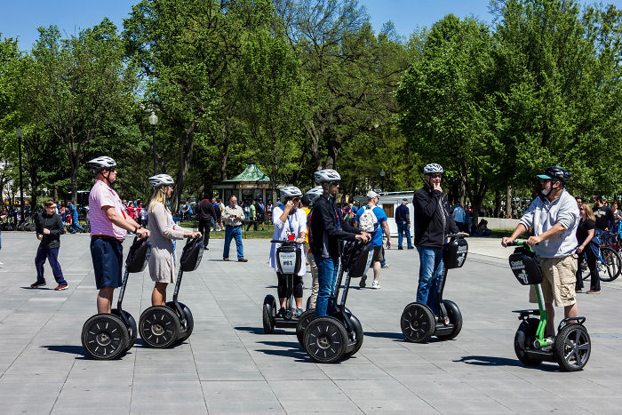 Group of people riding segways in a park, showcasing one of the hottest trends from the past decade.