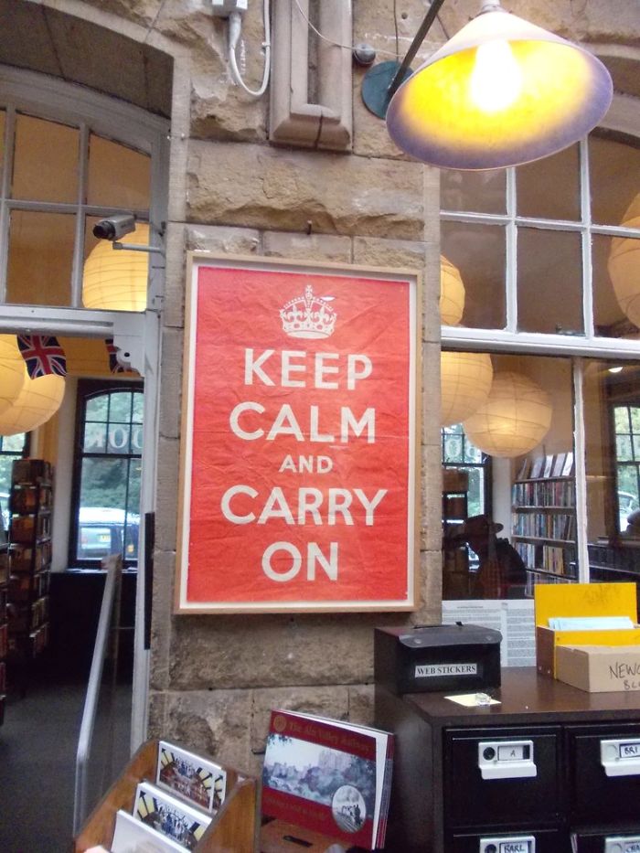 Keep Calm vintage poster displayed in a bookstore interior representing forgotten hottest trends from the past decade.