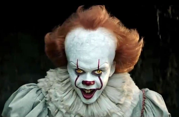 Pennywise clown with crossed eyes and eerie smile, showcasing natural makeup effects on a movie set. Pennywise clown with crossed eyes and eerie smile, showcasing natural makeup effects on a movie set.