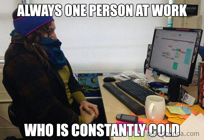 Person bundled up at a desk in an office, illustrating memes about being cold at work.