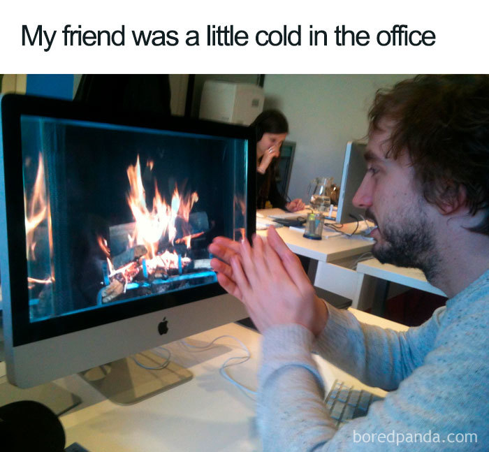 Office meme showing a person warming hands in front of a computer screen displaying a fireplace.