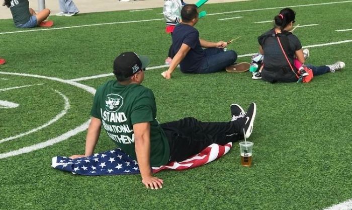 Brags About Standing For Anthem. Sits His Ass On Flag
