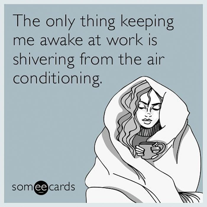 Office meme: person bundled in blanket, holding a cup, shivering from air conditioning.