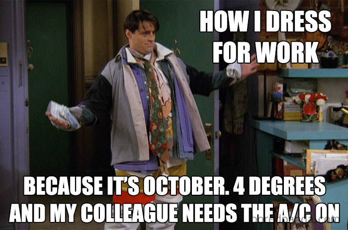 Man humorously dressed in many layers in office, highlighting the freezing temperature.