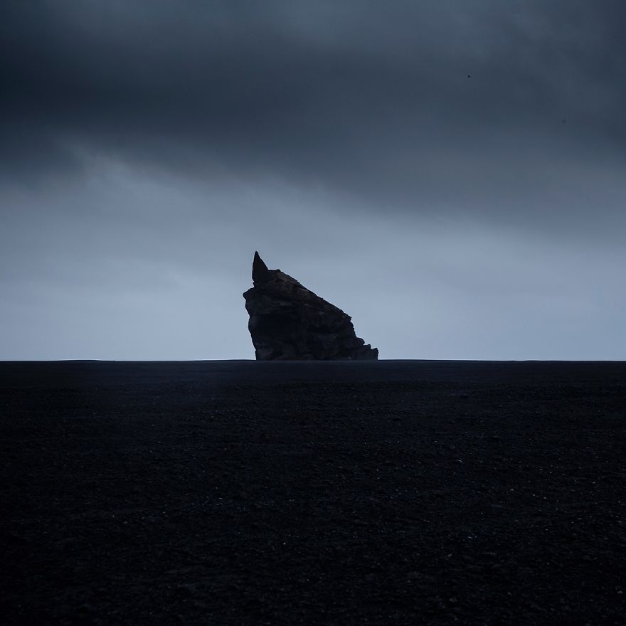 Volcanic Rock Towering Over An Endless Black Desert