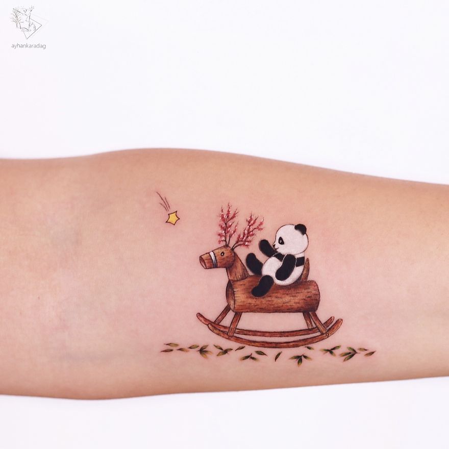Tattoo design of a panda on a wooden rocking horse with foliage, inked on human skin.