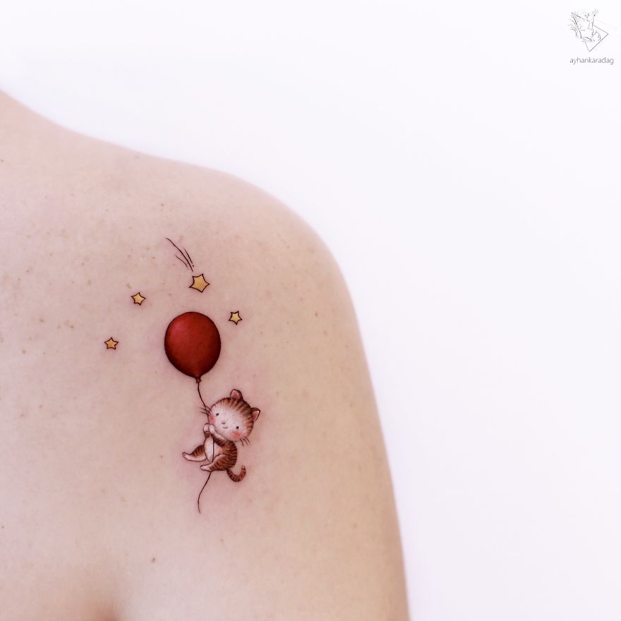 Cute cat tattoo with a red balloon and stars on human skin.